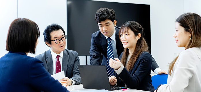 情熱を持って打ち合わせをする東横インの支配人とスタッフ4人