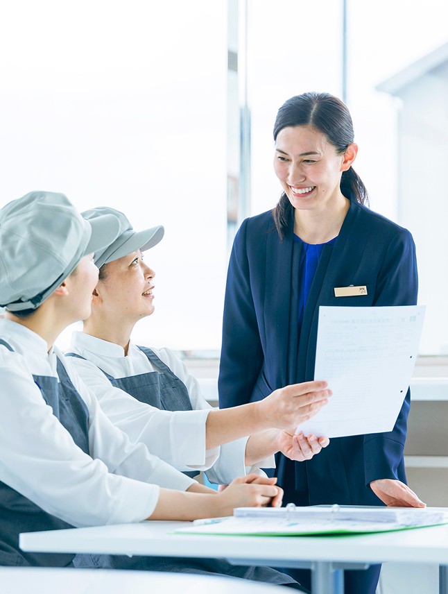 朝食スタッフと笑顔で話す支配人の女性