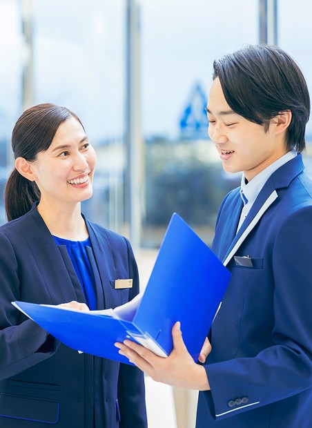 フロントスタッフに笑顔で話す支配人の女性