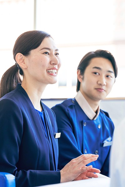 ホテルスタッフと笑顔で会話する支配人の女性